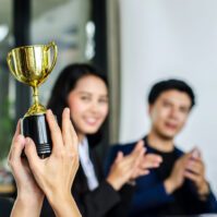 business-team-celebrating-achievement-with-a-troph-2026-03-26-22-47-34-utc